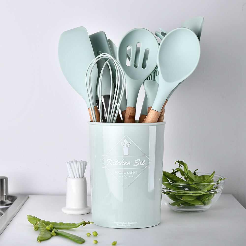 Complete set of silicone kitchen utensils including spatulas, spoons, and tongs in green and wood.